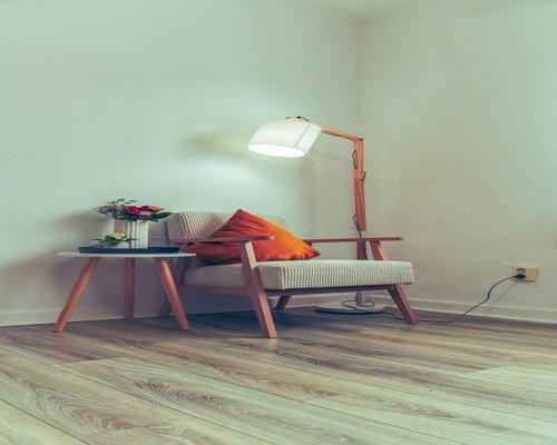 Cozy reading corner with warm lamp light on a rainy day