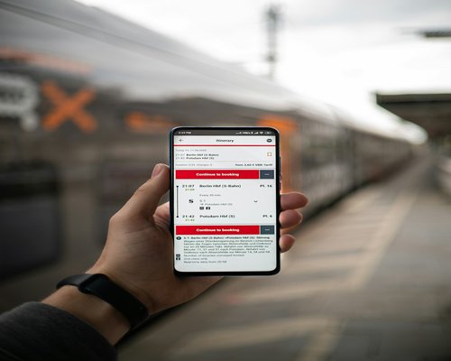 Person holding a smartphone with large text while sitting on a train